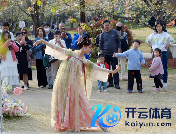 明朗假期技术，上海顾村公园樱花岛上，旅客在不雅赏国风汉服快闪饰演。（图片着手：视觉中国）